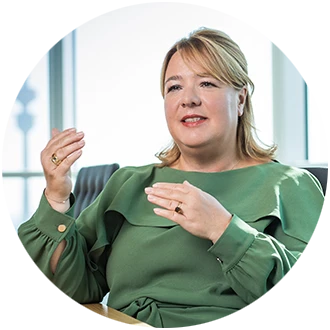 Valentina Daiber spricht, trägt grüne Bluse, sitzt vor hellem Hintergrund.