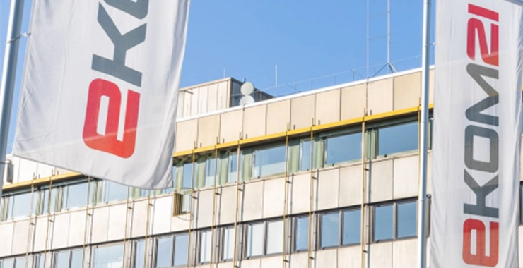 Two flags with the inscription “ekom21” in front of a building.